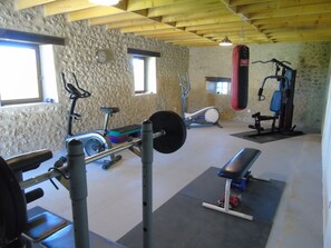 A gym with exercise equipment, a punching bag, and a window. - Holiday Home 'Limerac Pigeonnier' with Shared Pool, Shared Terrace and Wi-Fi (Salles-Lavalette)