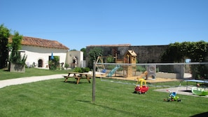 A fenced outdoor play area with a slide, swings, and a picnic table. - Holiday Home 'Limerac Farmhouse' with Shared Pool, Shared Terrace and Wi-Fi (Salles-Lavalette)