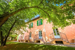 A building with a pink facade, green shutters, and a central entrance with a staircase leading to a balcony. - Tenuta La Fiscala (Alessandria)