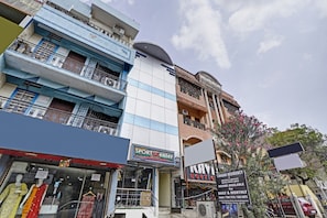 A multi-story building with various shops on the ground floor, including a sports center and a boutique.