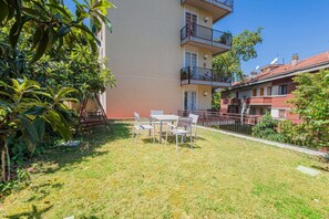 A residential building with a balcony, a small outdoor seating area with chairs and a table, and a well-maintained lawn. - UR NEST Tullio Levi Civita - Prestigious 3 bedroom apartment in the first hills of Bologna (Bologna)