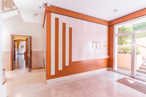 A hotel lobby with a modern design, featuring a large glass door entrance, a wooden accent wall, and a tiled floor. - UR NEST Tullio Levi Civita - Prestigious 3 bedroom apartment in the first hills of Bologna (Bologna)