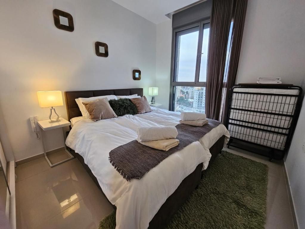 Une chambre d’hôtel avec un lit, deux lampes de chevet, une fenêtre avec des rideaux et un radiateur.