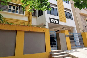 A multi-story building with a prominent 'OYO' sign, a gated entrance, and a staircase leading to the entrance. - Hotel O Anvi (Bhubaneshwar)