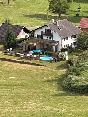 A residential property with a swimming pool, a covered patio, and a large lawn. - Basel Landskron Haus (LEYMEN)