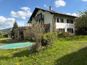 A two-story house with a balcony, a swimming pool, and a garden with flowers. - Basel Landskron Haus (LEYMEN)