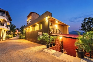 A two-story building with a sign indicating it's a resort. There are potted plants and a red brick wall in front. - Mist Valley Resort (Mahabaleshwar)