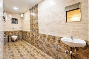 A bathroom with a toilet, a sink, and a shower. - Mist Valley Resort (Mahabaleshwar)