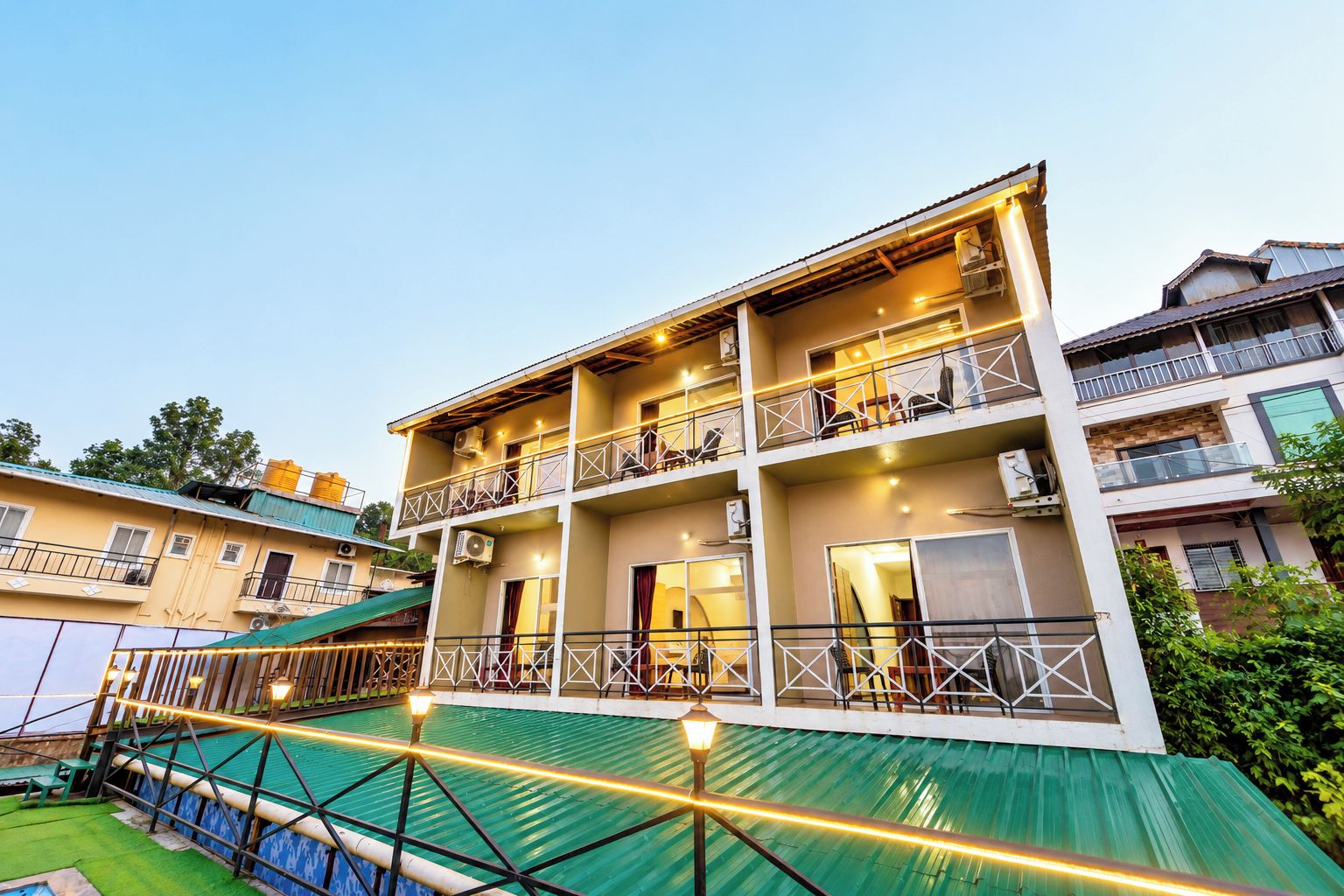 Hotel com vários andares, varandas, ar condicionado e área de piscina.