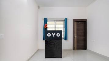 A room with a black podium, a window with blue curtains, and a closed door.