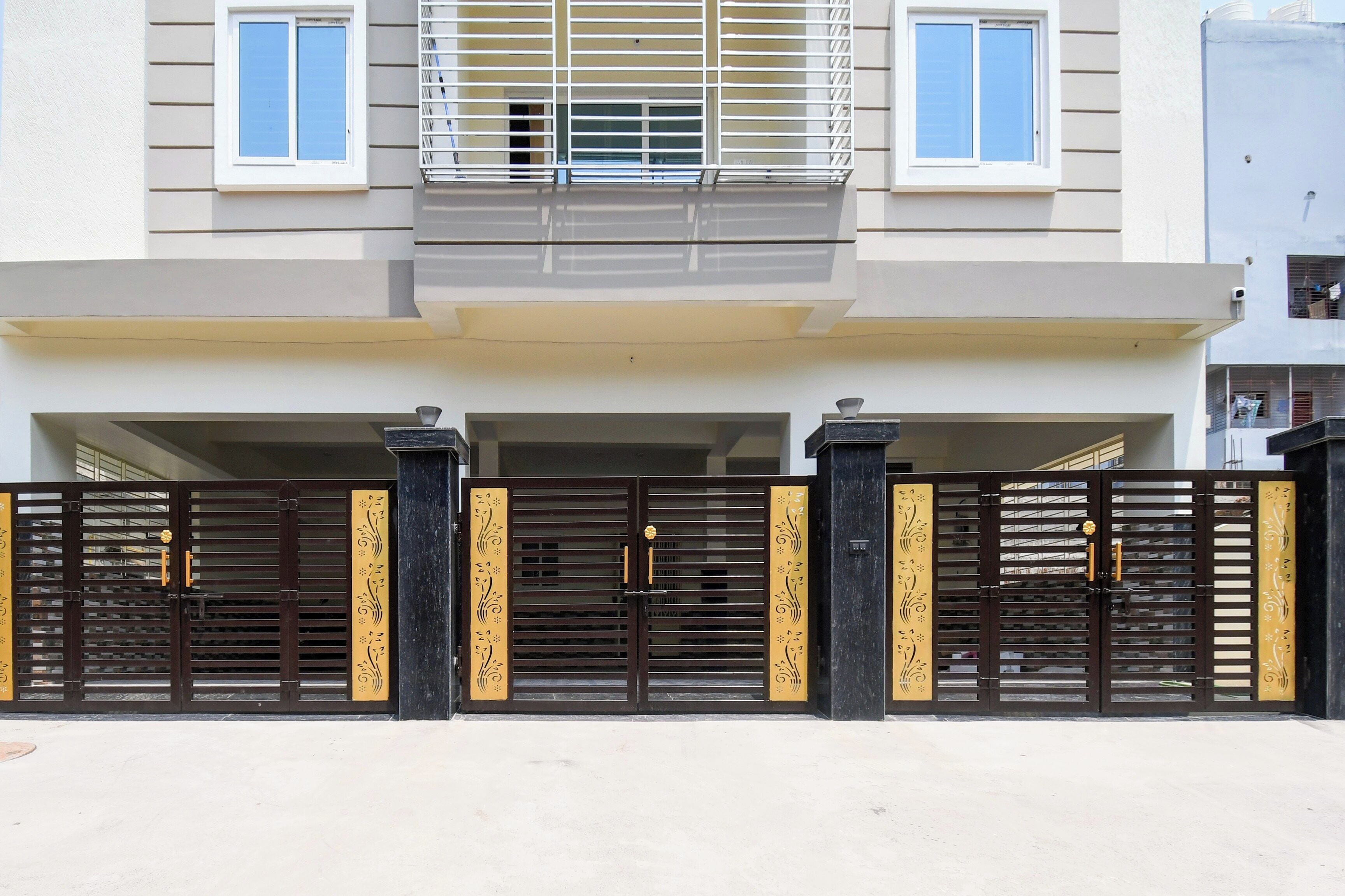 Um edifício residencial com vários andares, portão fechado, varandas e telhado plano.