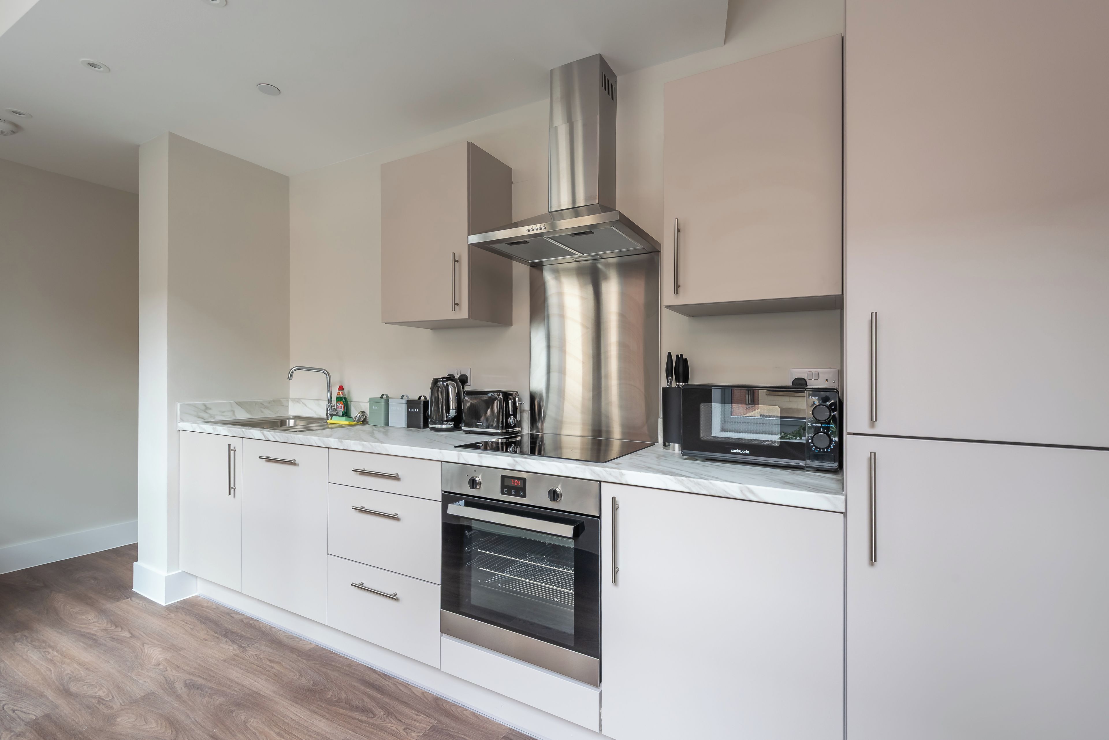 A modern kitchen with stainless steel appliances, a built-in oven, and a microwave.