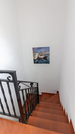 A staircase with a railing and a painting of boats on the wall. - Casa del Sol Playa del los Locos Torrevieja (Torrevieja)
