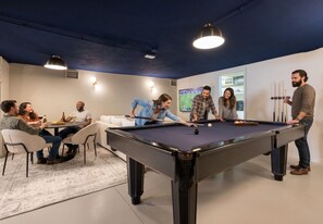A pool table in a room with a group of people around it, a sofa, and a table with drinks. - Lapa Diplomatic Residence by Feel Lisbon (Lisbon)