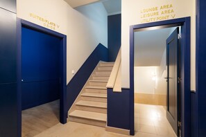 Eine Treppe führt zu einer Lounge mit einem Schild, das es als Versorgungsstation kennzeichnet.