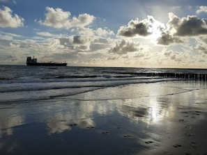 A beach with a ship in the distance and a cloudy sky. - Holiday Cottage With 1 Bedroom (Zoutelande)