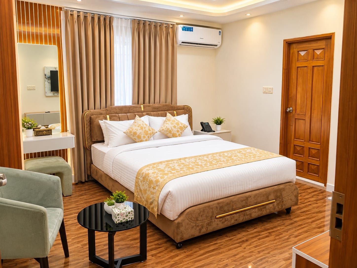 A hotel room with a bed, bedside table, chair, and a small round table with a plant.
