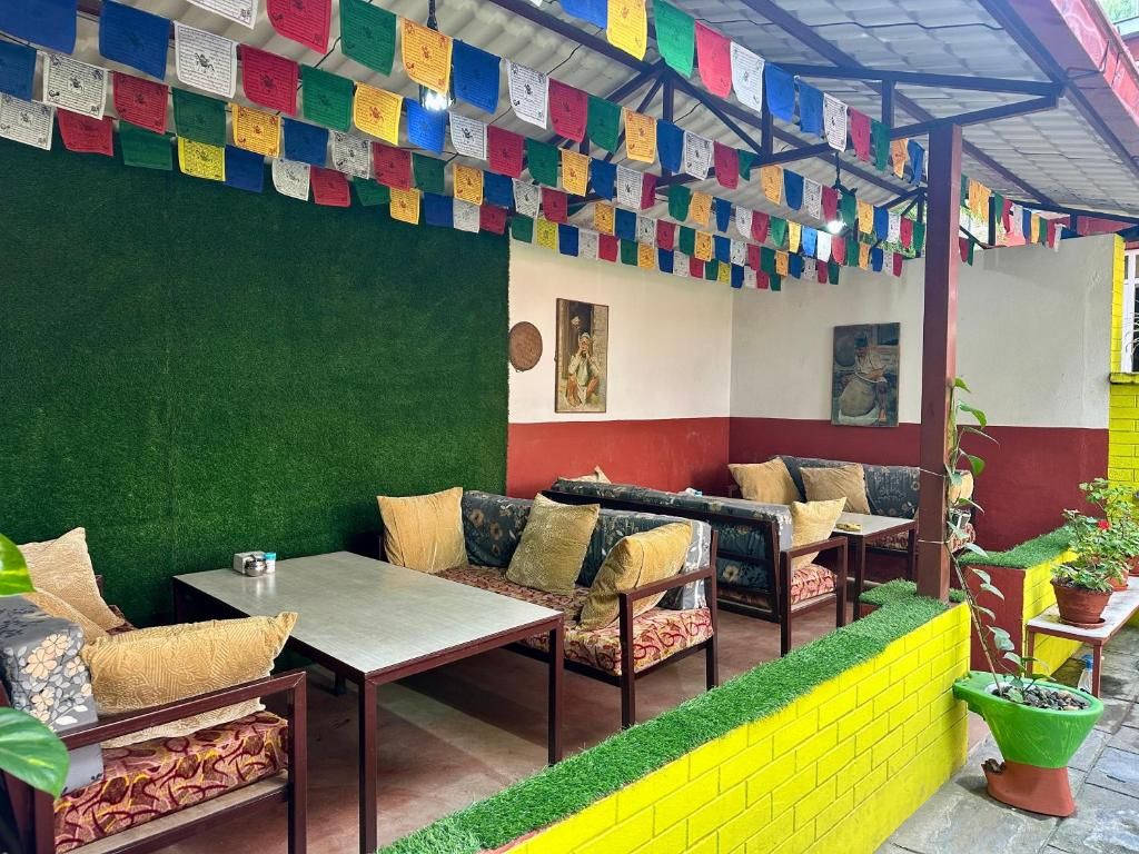 A seating area with tables and sofas, a green wall, and colorful prayer flags.