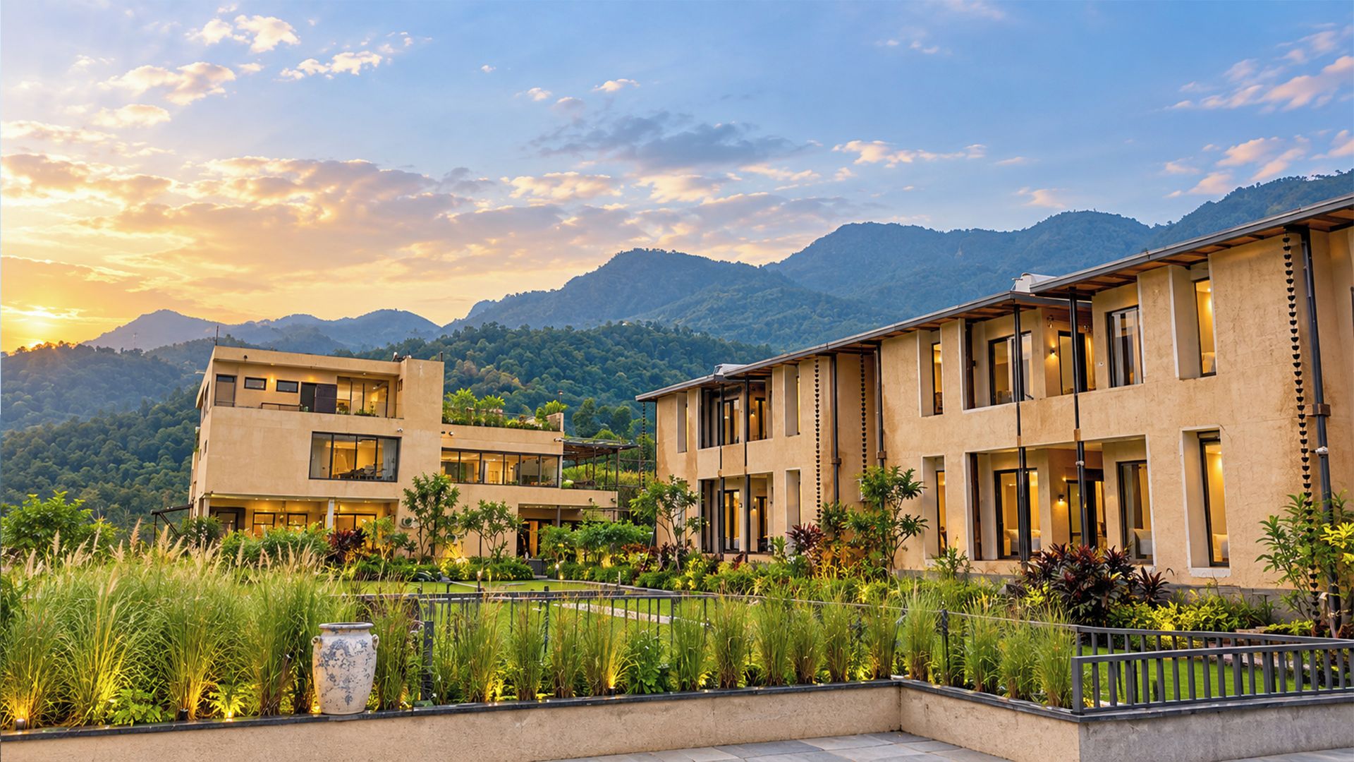 A modern hotel with a flat roof, large windows, and a view of mountains.