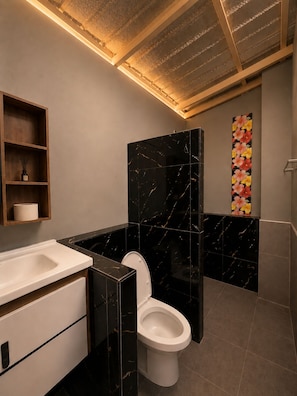 A modern bathroom with a toilet, vanity, and a decorative wall. - Siam Old Town BKK (Phra nakhon)