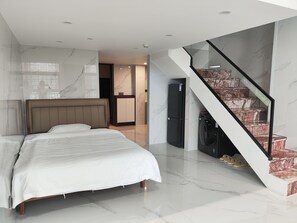 Un dormitorio moderno con una cama grande, un armario empotrado y una escalera de mármol.