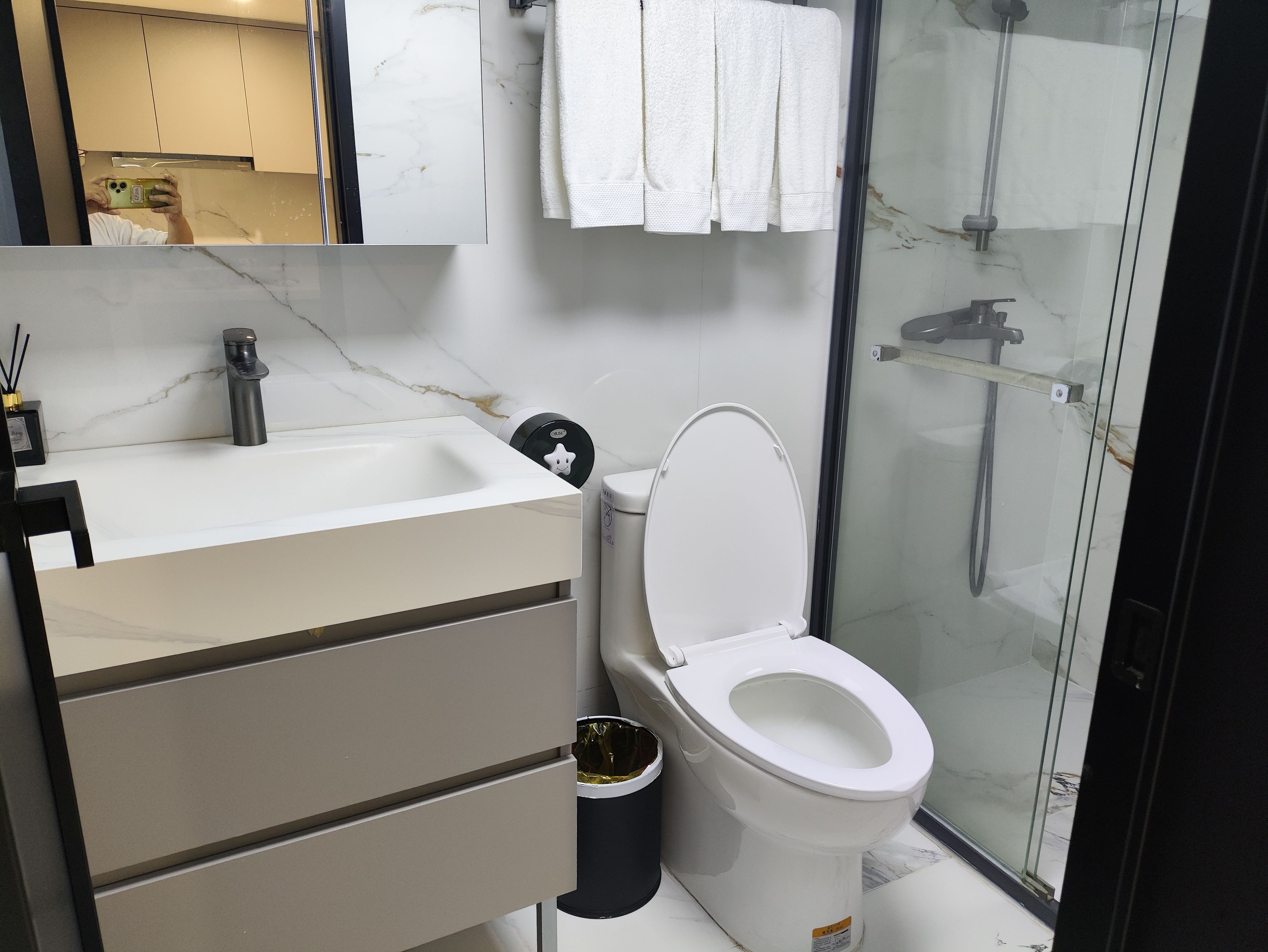 Un baño moderno con inodoro, lavabo y zona de ducha.