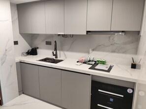 Una cocina moderna con gabinetes grises, un grifo negro y un lavavajillas integrado.