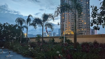A rooftop garden with plants and a view of high-rise buildings.