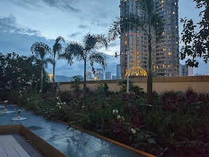 A rooftop garden with plants and a view of high-rise buildings. - Healing Warm Home (Shen Zhen Shi)