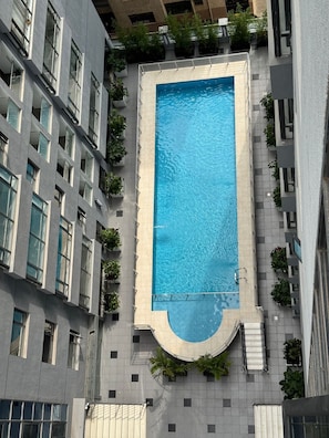 A rectangular swimming pool surrounded by a building with multiple floors and balconies. - Elagant 2BR in lavington/kilimani/kileleshwa w/pool gym near malls central place (Nairobi)