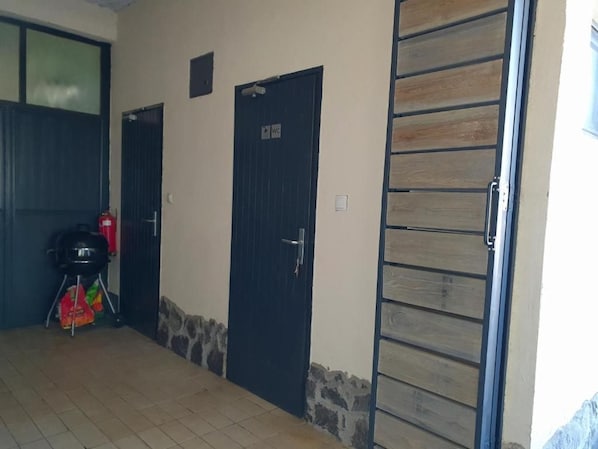 Un pasillo con dos puertas, una con la indicación 'WC' y otra con un cartel encima.