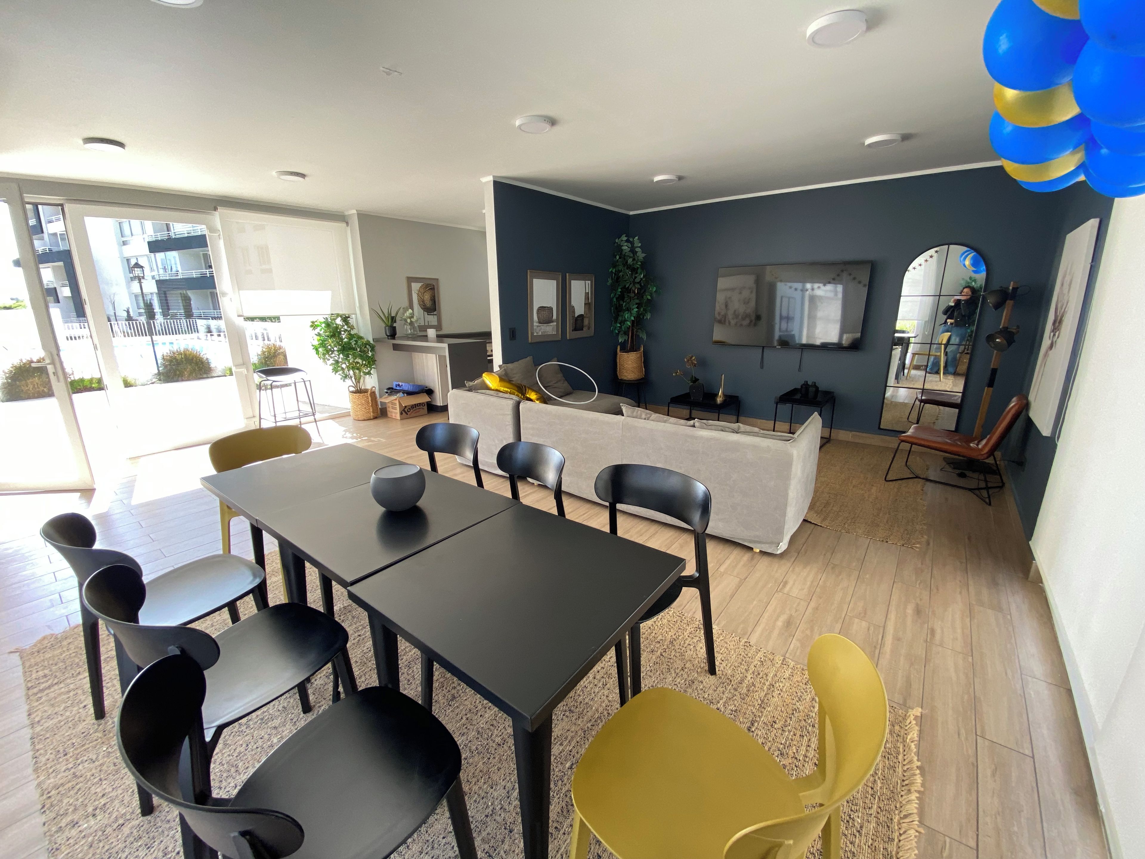 Un intérieur moderne avec un coin repas, un canapé et une cuisine en arrière-plan.