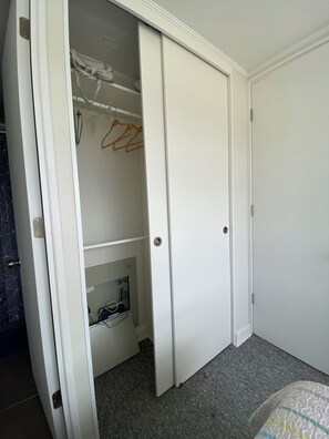 Ein Zimmer mit Schrank, Kleidung und integriertem Stromverteiler.