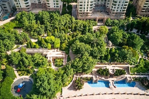 Un complejo residencial con varios edificios de gran altura, un patio central con árboles y una zona de piscina.