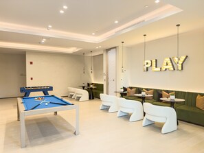 A modern lounge area with a pool table, comfortable seating, and a wall sign that reads 'PLAY'. - Rentico | 1BR Marina Waterfront | Pool & Cinema (Dubai)