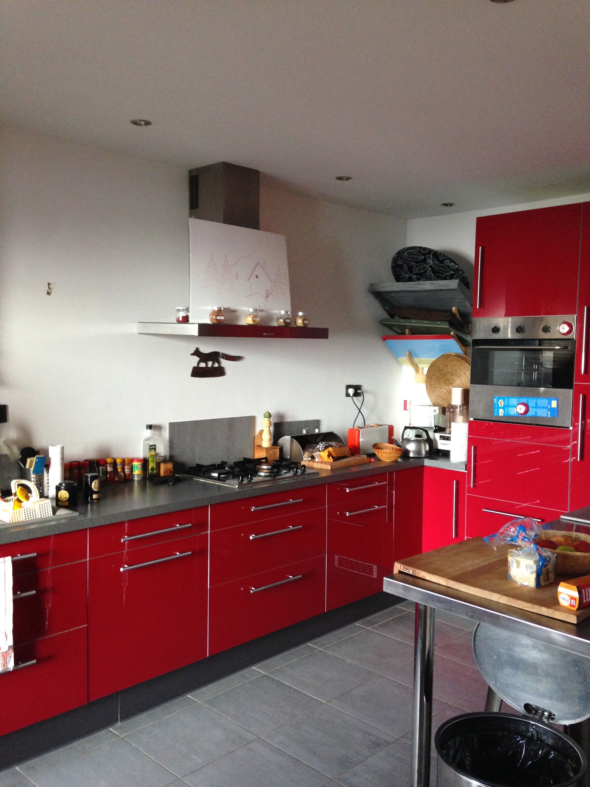 A kitchen with red cabinets, a gas stove, and a microwave.