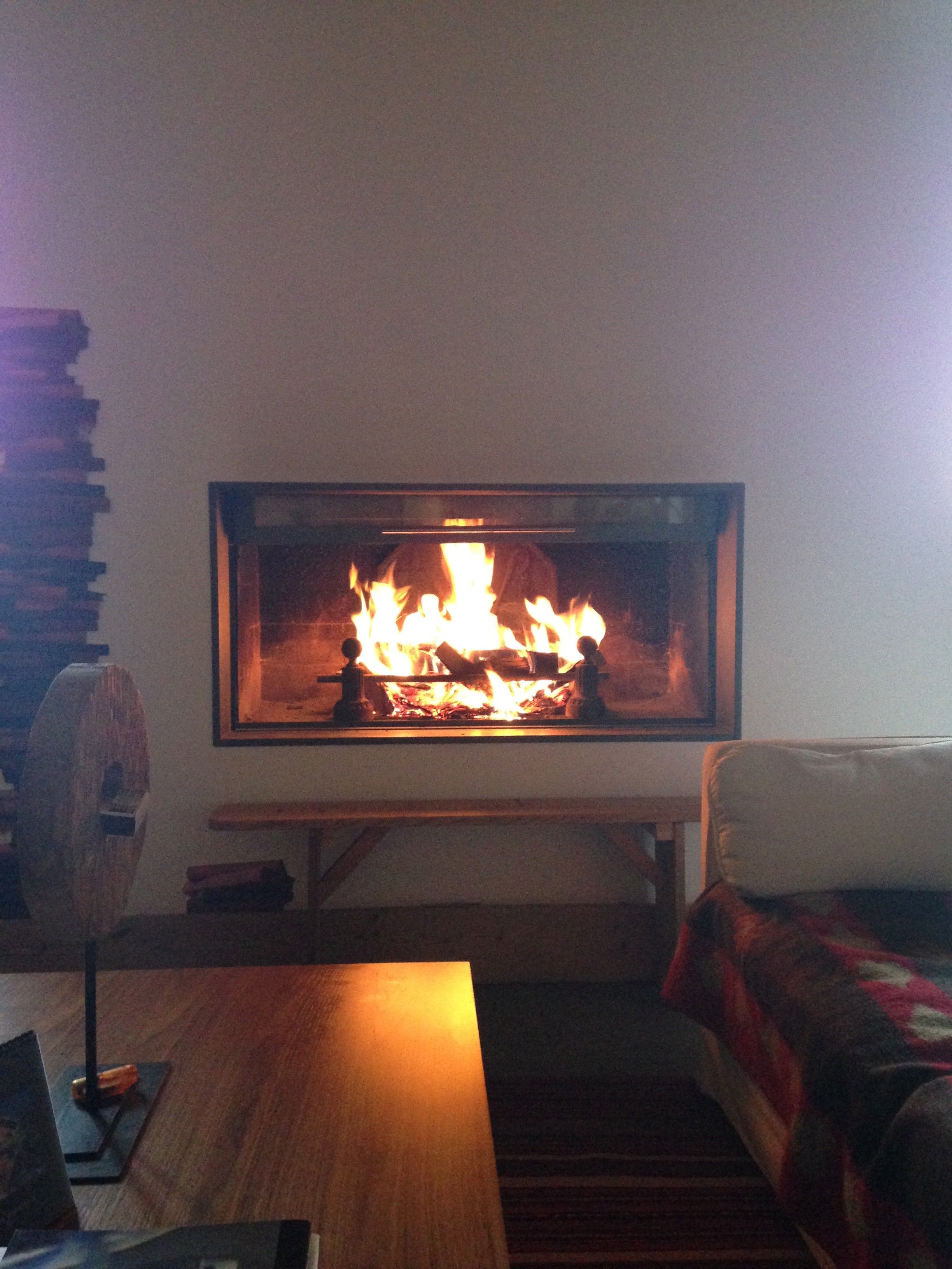 A room with a fireplace, a wooden table, and a couch.