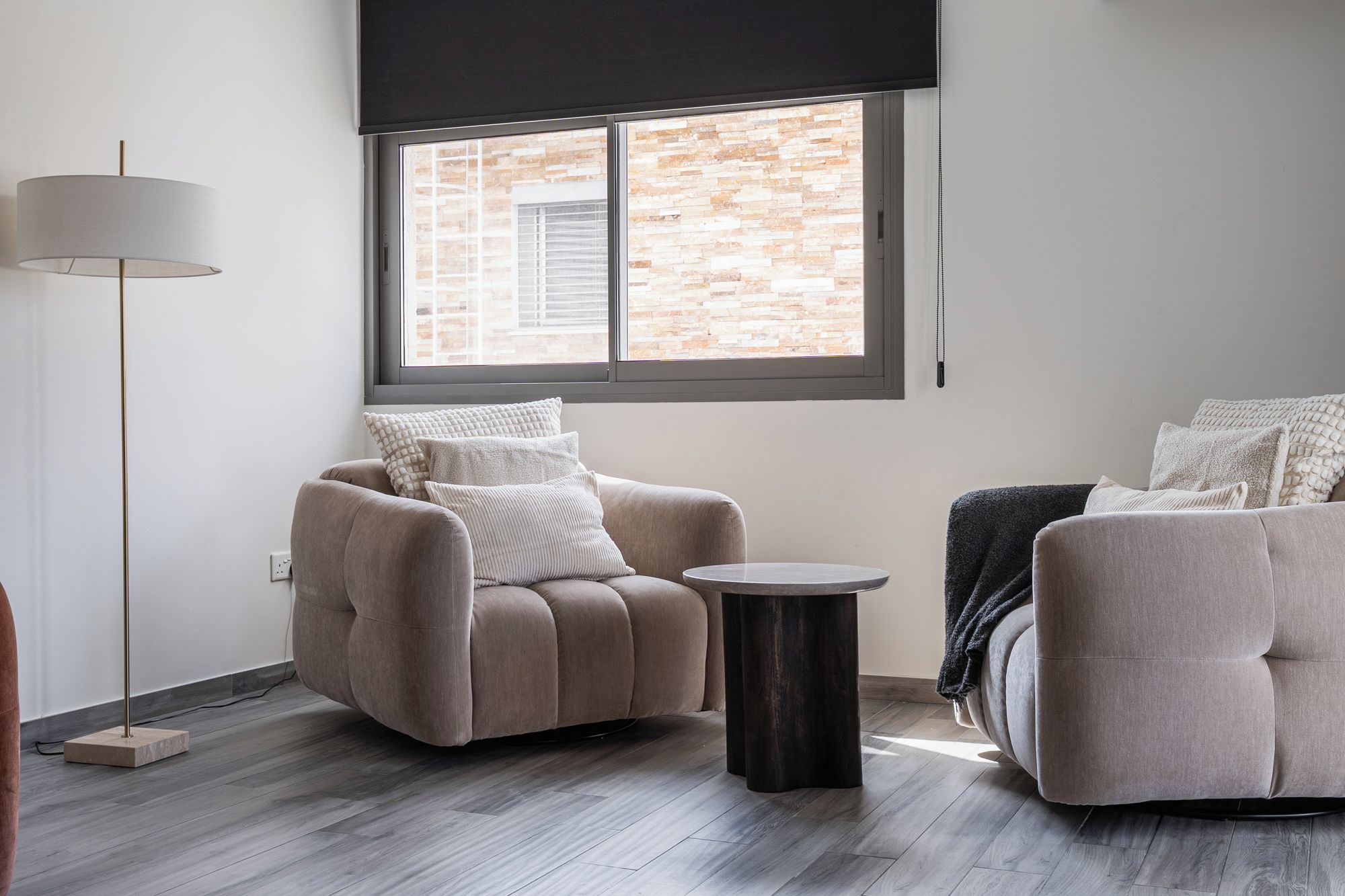A modern living room with a sofa, a round coffee table, and a floor lamp.