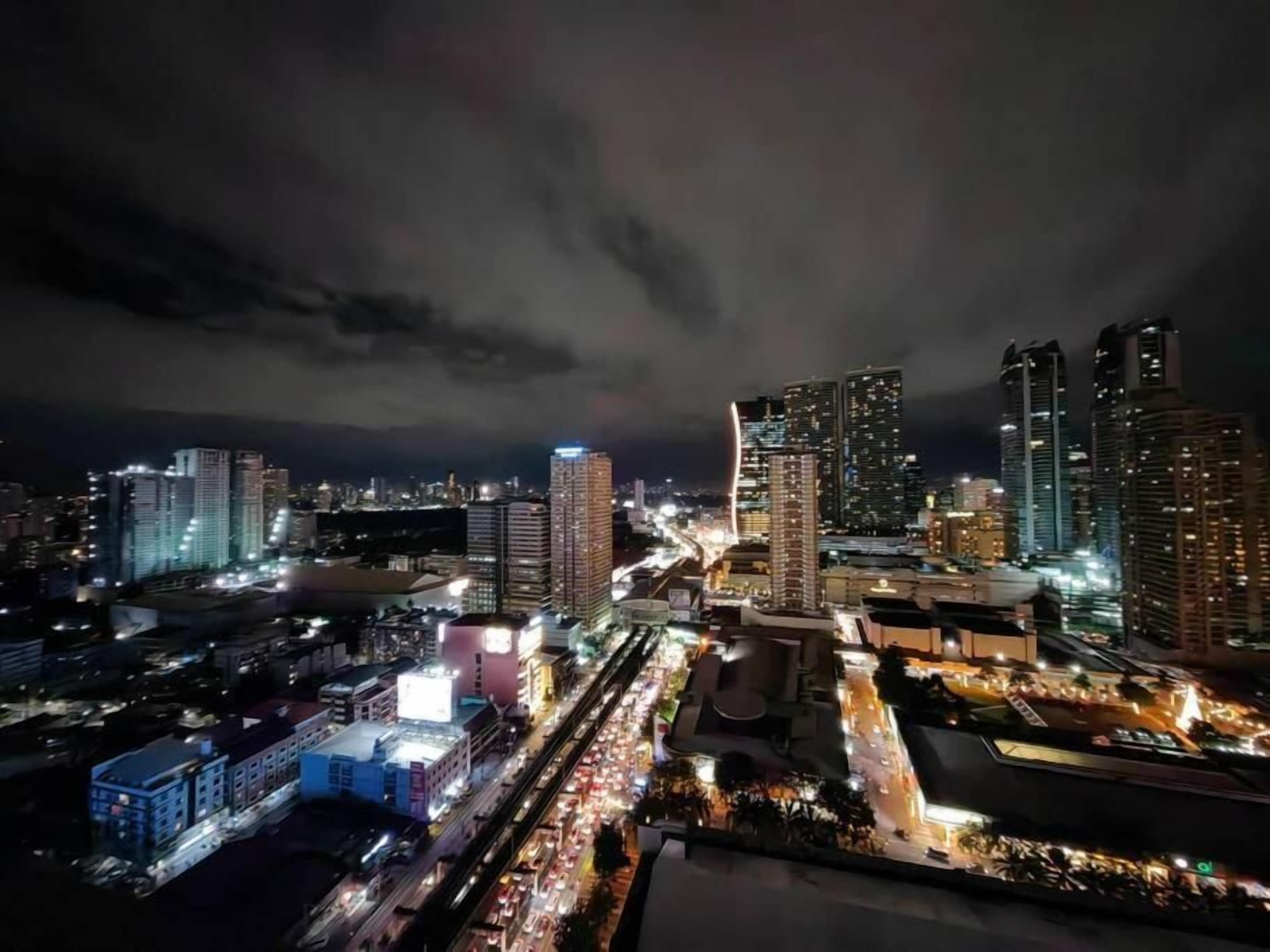 Un paisaje urbano nocturno con rascacielos y calles concurridas.