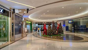A shopping mall interior with a Christmas tree display, a sign for 'Exit to Mayflower St. Parking', and a BDO store.