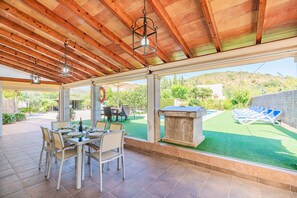 An outdoor patio with a dining table set for four, surrounded by chairs. - Villa Santuiri Can Tomeu - By Dream Villas Pollensa (Pollensa)