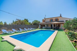 A swimming pool with lounge chairs, a patio area with outdoor furniture, and a house with a tiled roof. - Villa Santuiri Can Tomeu - By Dream Villas Pollensa (Pollensa)