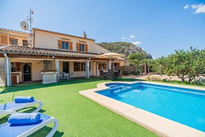 Una proprietà residenziale con piscina, mobili da esterno e vista su una montagna.