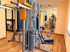 A gym with various exercise equipment, including a squat rack and weight machines.