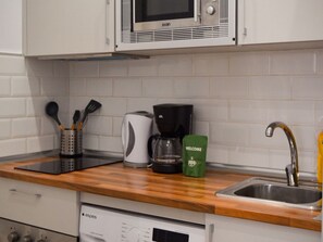 A kitchen with a microwave, coffee maker, and a green welcome bag on the counter. - Pet-friendly Stay in Madrid (Madrid)