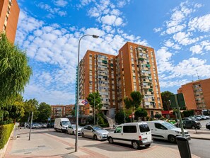 A multi-story residential building with balconies, parked cars, and a clear sky. - Pet-friendly Stay in Madrid (Madrid)