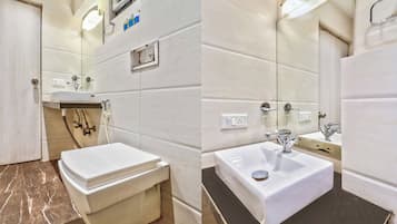 Un baño con inodoro, lavamanos y espejo.