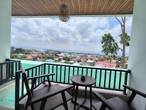 A balcony with a view of a town and a body of water. - Wisma SIDAPORE JD (Banggai)