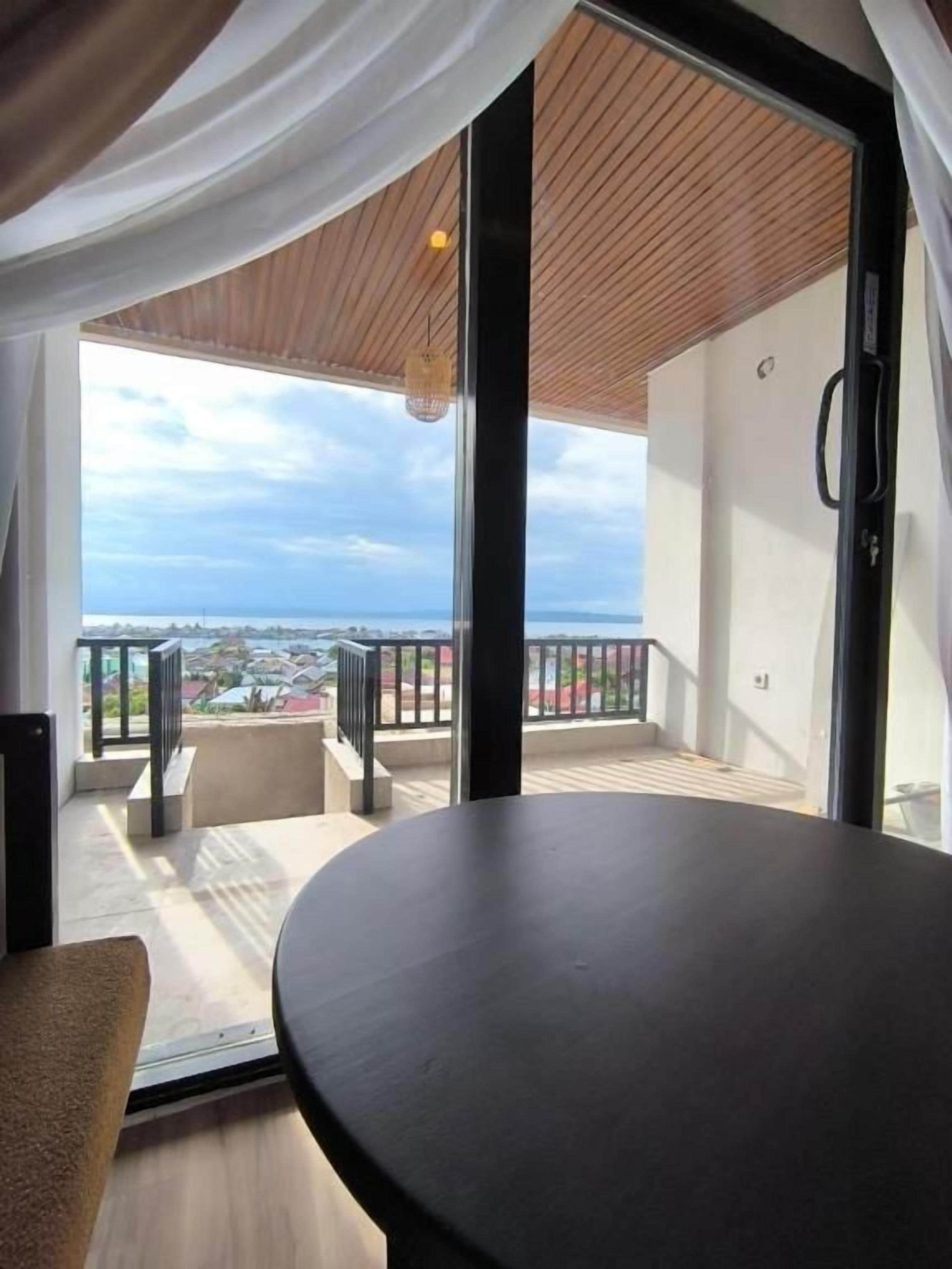 Ein Balkon mit Blick auf eine Stadtlandschaft, einem runden Tisch und einem Stuhl.