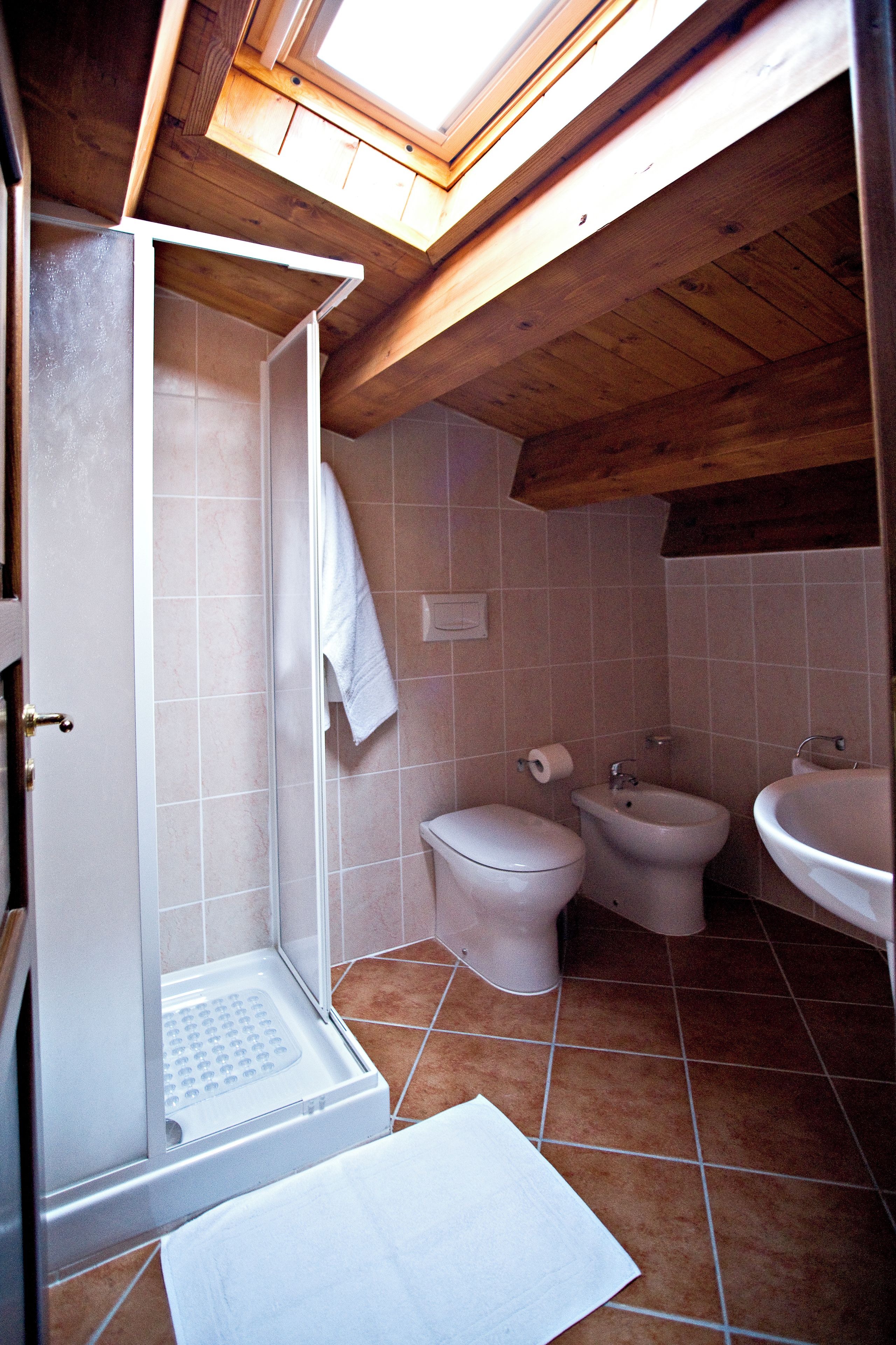Ein Badezimmer mit Dusche, Toilette, Bidet und Waschbecken.